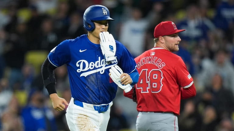 Los Angeles Dodgers' Shohei Ohtani, left, smiles as he heads...