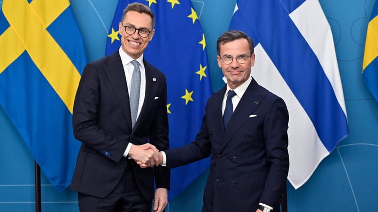 President of Finland Alexander Stubb, left, is received by Sweden's...