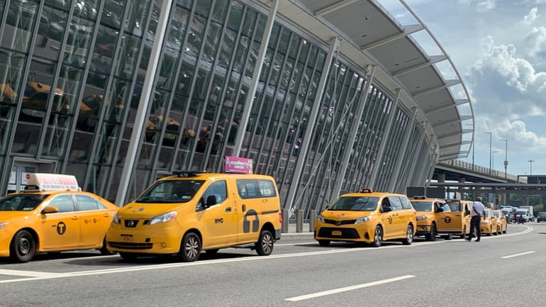 Taxis wait to pick up passengers outside Terminal 4 at Kennedy Airport...