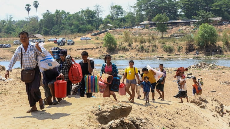 People cross the Moei river as they flee Myawaddy township...
