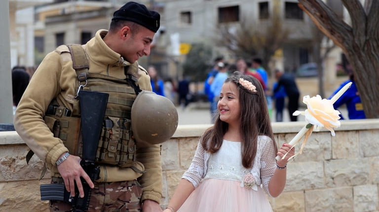 A Lebanese army soldier speaks with a girl as he...