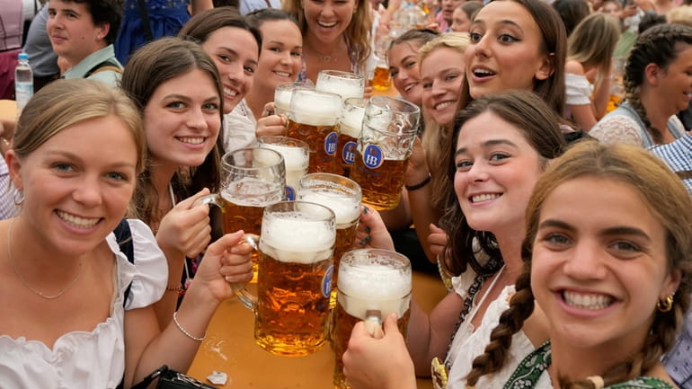 Women with glasses of beer pose for a photo on...