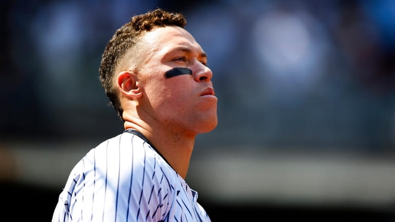 The Yankees' Aaron Judge looks out from the dugout during...