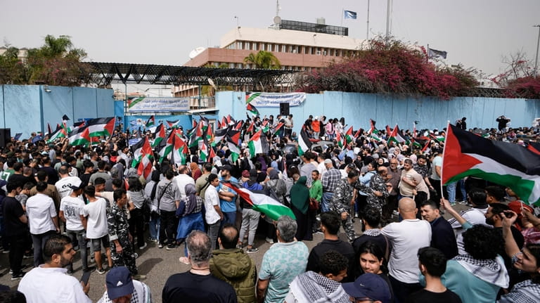 Protesters wave Palestinian flags during a sit-in in solidarity with...