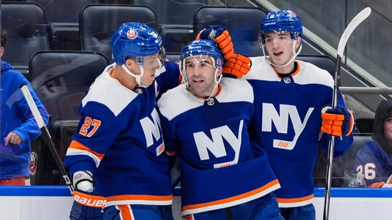 Islanders' Kyle Palmieri, center, celebrates with Anders Lee, left, and...