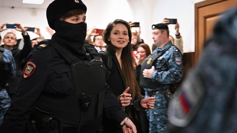 Antonina Favorskaya is escorted by a police officer to the...