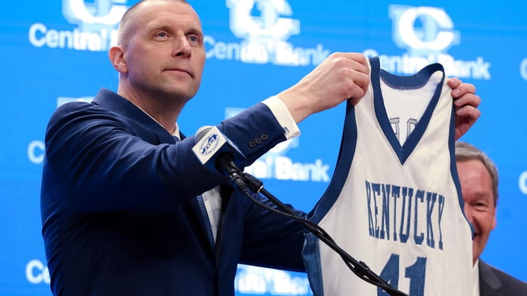 New Kentucky men's basketball head coach Mark Pope holds up...