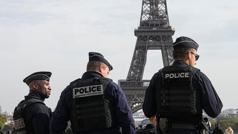 Police officers patrol the Trocadero plaza near the Eiffel Tower...