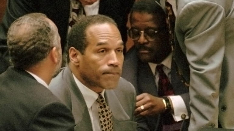 O.J. Simpson is surrounded by his defense team during his...