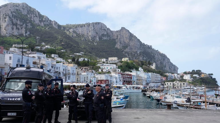 Italian Carabinieri paramilitary policemen gather at the Capri's harbour, Wednesday,...
