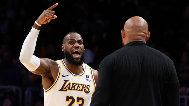 Los Angeles Lakers forward LeBron James, left, asks head coach...
