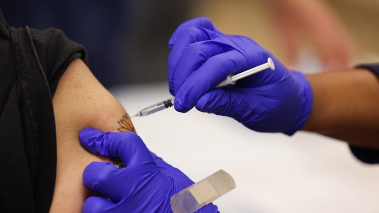 A Pfizer COVID-19 vaccine booster shot is administered at the Mount...