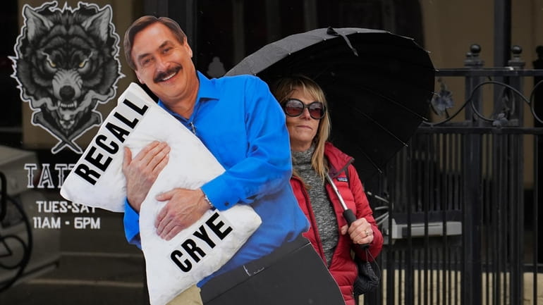 Stacy Oliver holds display of Mike Lindell, the controversial CEO...