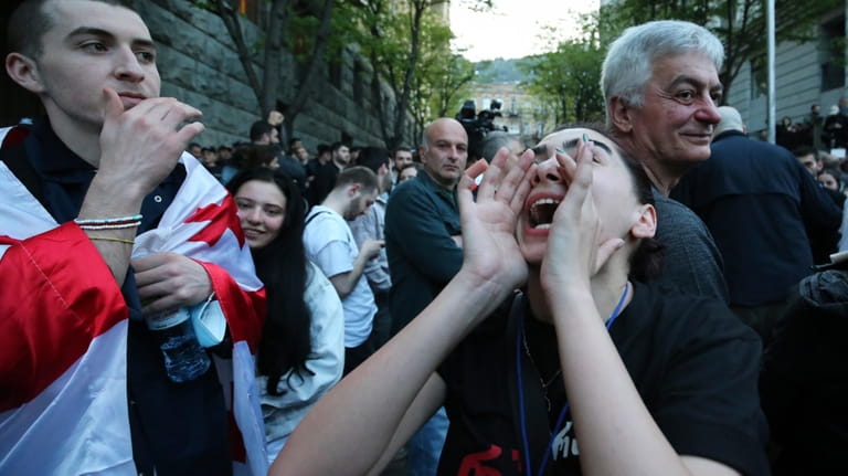 A protester shouts outside the parliament building in Tbilisi, Georgia,...