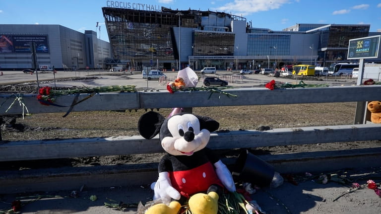 Toys and flowers lie in front of the Crocus City...