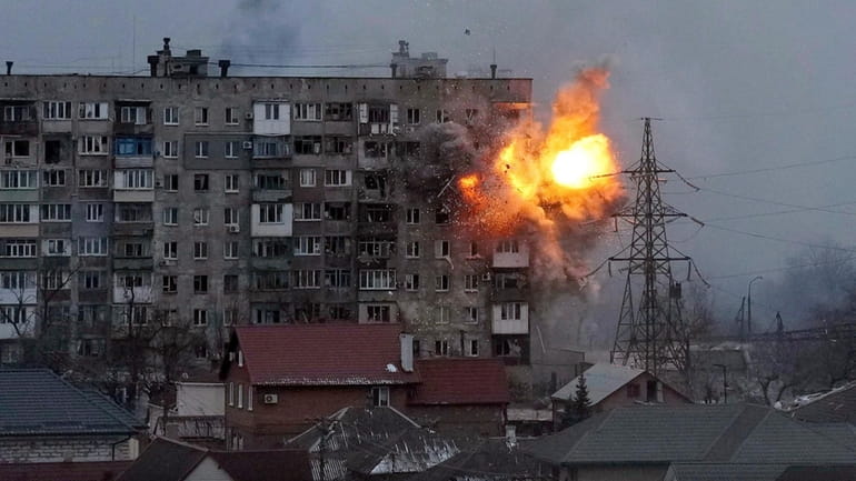 A Russian army tank fires on an apartment building in...