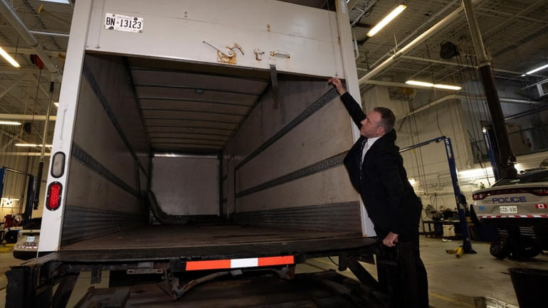 Police officers open the back of a recovered truck during...