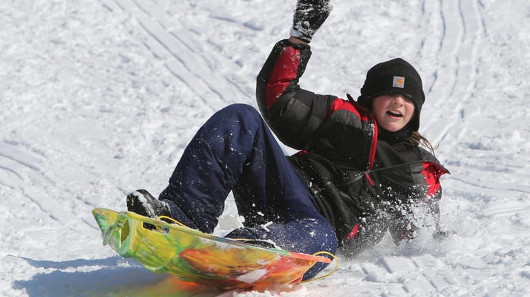 Michael Watson sledding down a hill at Hempstead Lake State...