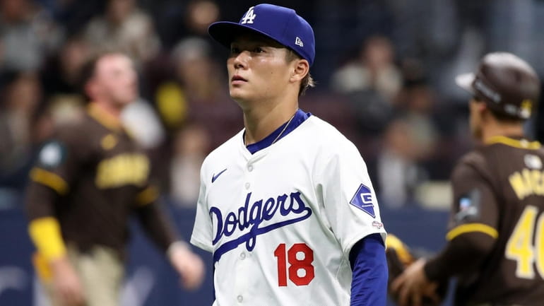 Yoshinobu Yamamoto #18 of the Los Angeles Dodgers reacts after...