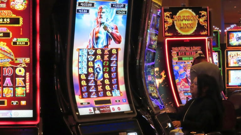A gambler plays a slot machine at Harrah's casino in...