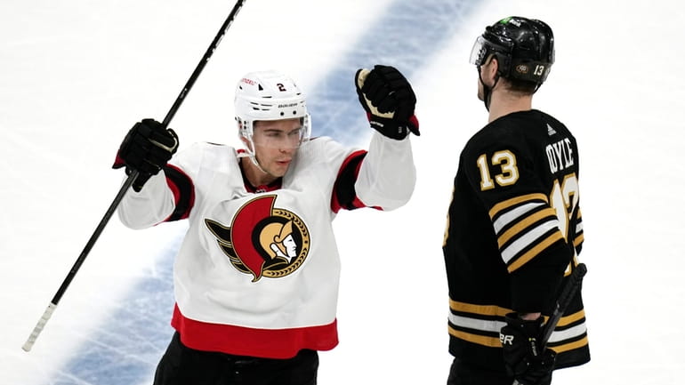 Ottawa Senators defenseman Artem Zub, left, skates past Boston Bruins...