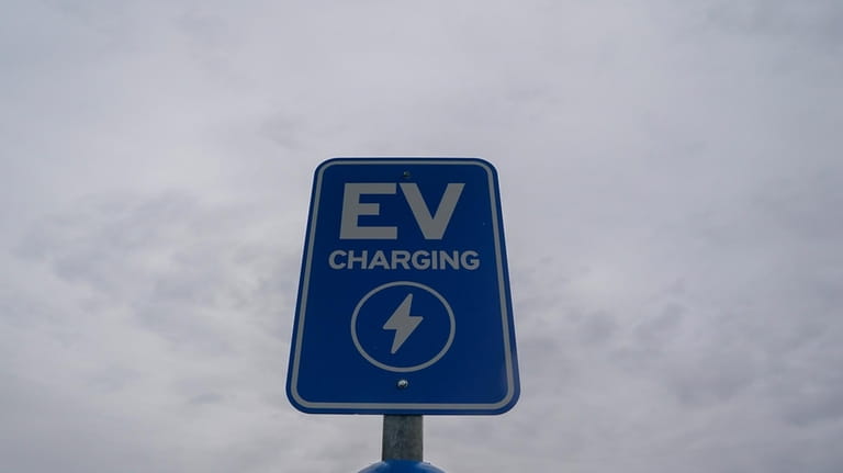 A sign sits at an electric vehicle charging station, Friday,...