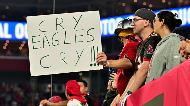 A Buccaneers fan holds a sign that reads, "Cry Eagles Cry!!!"...