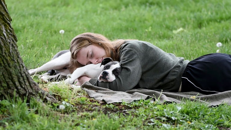 FILE -A woman and her dog nap between rain showers...
