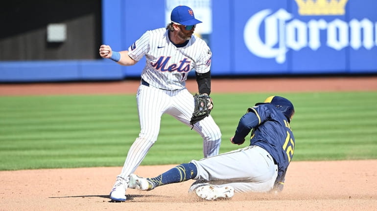 The Brewers’ Rhys Hoskins slides into Mets second baseman Jeff...