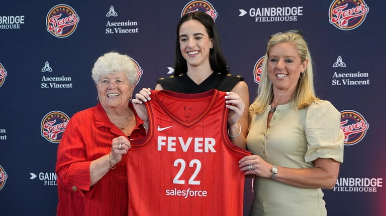 Indiana Fever's Caitlin Clark, middle, poses with general manager Lin...