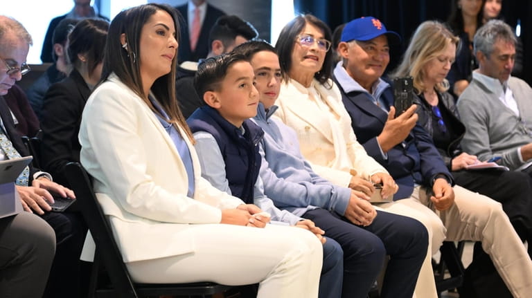 Carlos Mendoza's family, including wife Francis (left), watch his introductory press conference...
