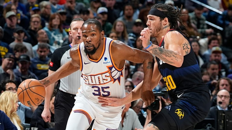 Phoenix Suns forward Kevin Durant drives past Denver Nuggets forward...