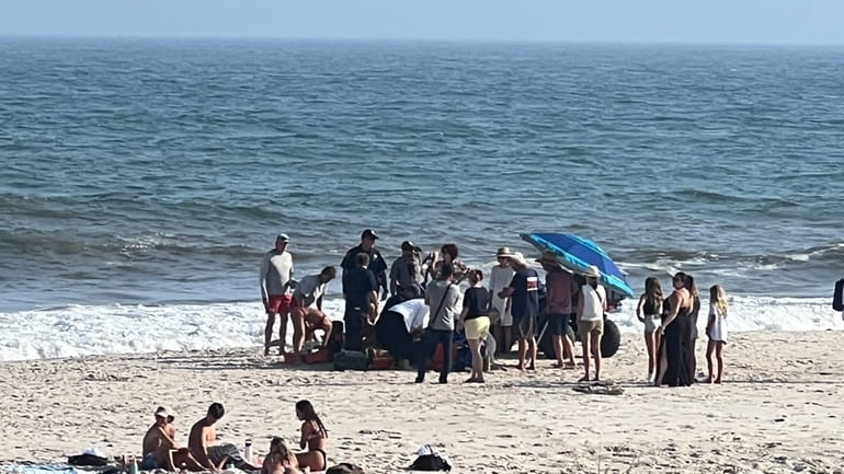 People gather on the beach to aid a 15-year-old boy...