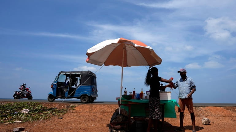 A man buys a cool drink from a roadside vendor...