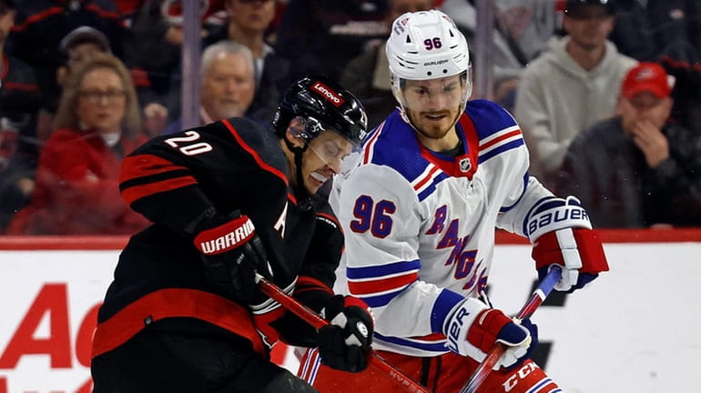 The Hurricanes' Sebastian Aho works for the puck against the Rangers'...