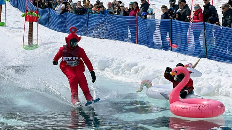 A skier dressed as a Teletubbie participates in a pond...