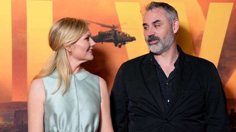 Kirsten Dunst, left, and Alex Garland pose for photographers on...