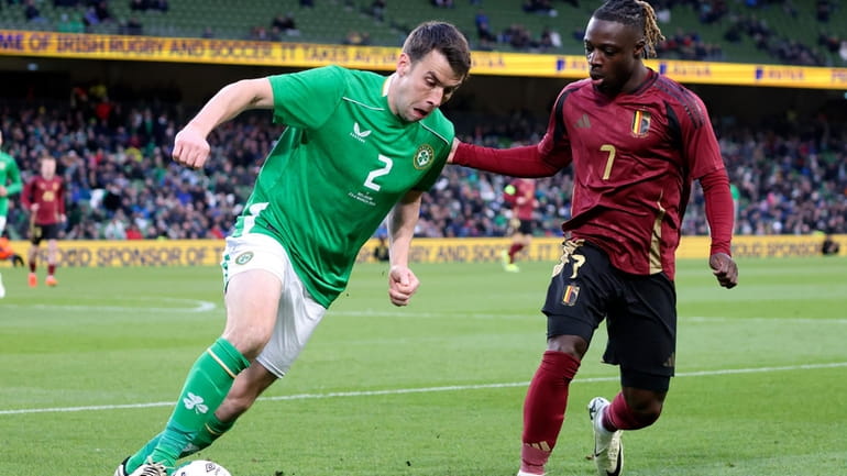 Ireland's Seamus Coleman , left, and Belgium's Jeremy Doku challenge...