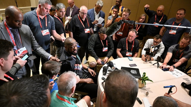 Pittsburgh Steelers head coach Mike Tomlin, center, talks with reporters...