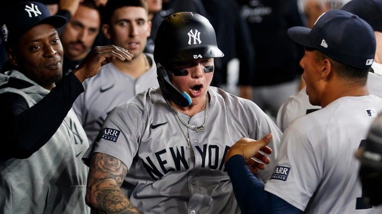 Alex Verdugo #24 of the Yankees celebrates in the dugout...