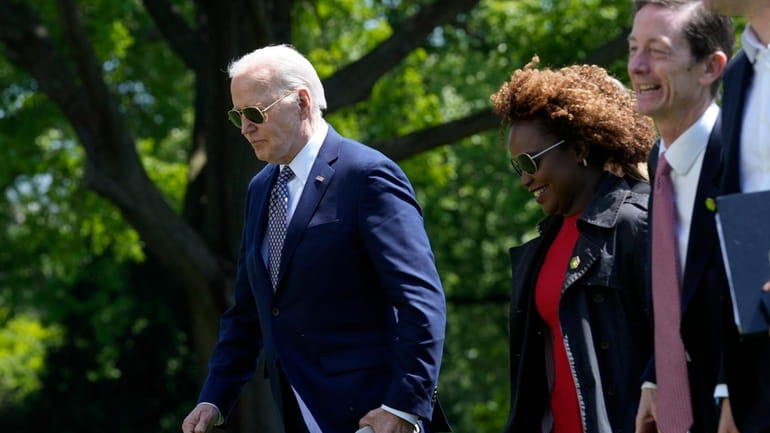 President Joe Biden, from left, walks with White House press...