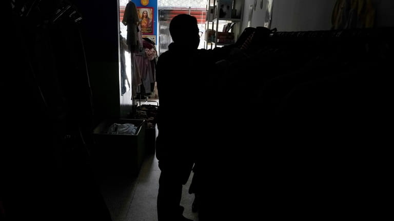 A customer shops for clothes in a store without electricity...