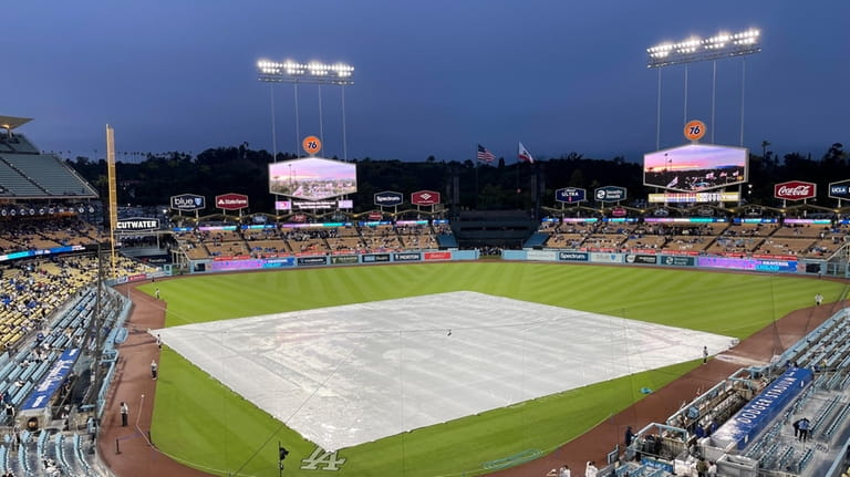 A tarp covers the field during a rain delay before...