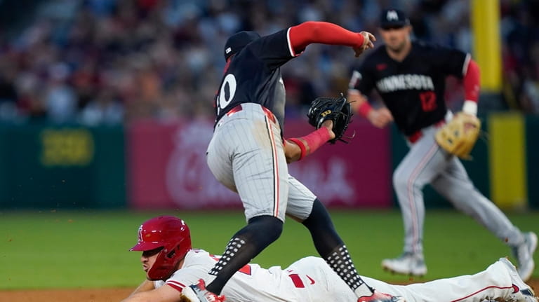 Los Angeles Angels' Mike Trout, bottom, is picked off stealing...