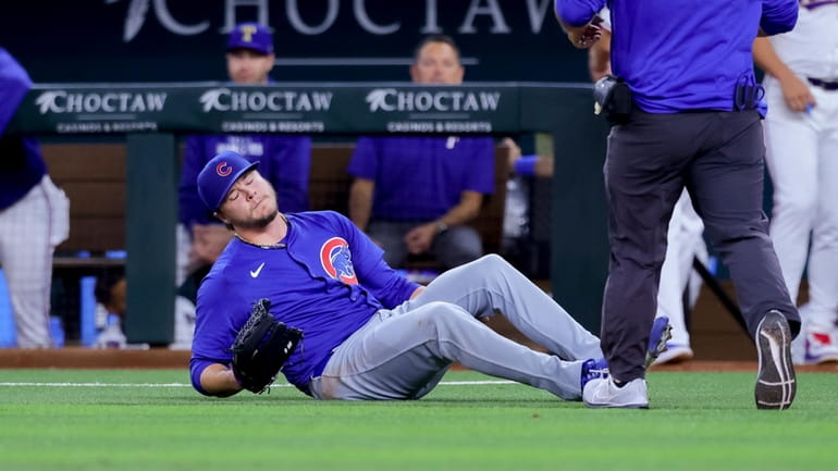 Chicago Cubs starting pitcher Justin Steele falls to the ground,...