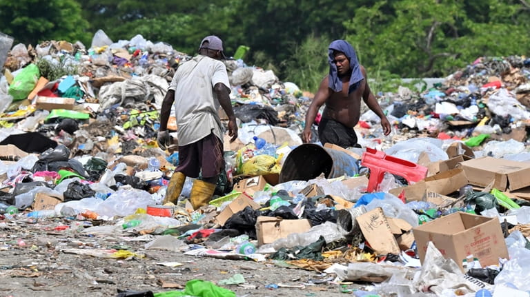 Residents who live on the Ranadi Landfill site scavenge through...