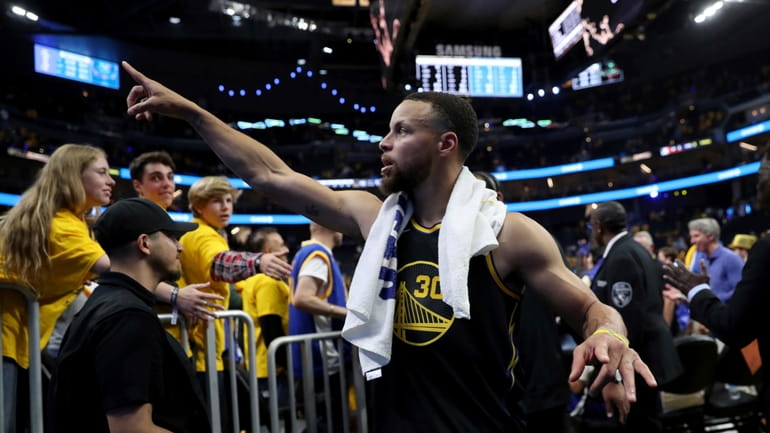 Golden State guard Stephen Curry (30) gestures to the crowd...