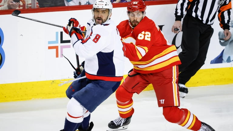 Washington Capitals forward Alex Ovechkin (8) checks Calgary Flames defenseman...