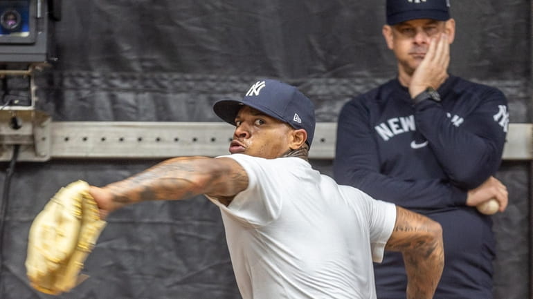 Yankees pitcher Marcus Stroman throws in the bullpen, overseen by manager...