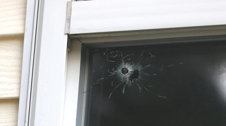 A bullet hole in a window of a house on Cedar...